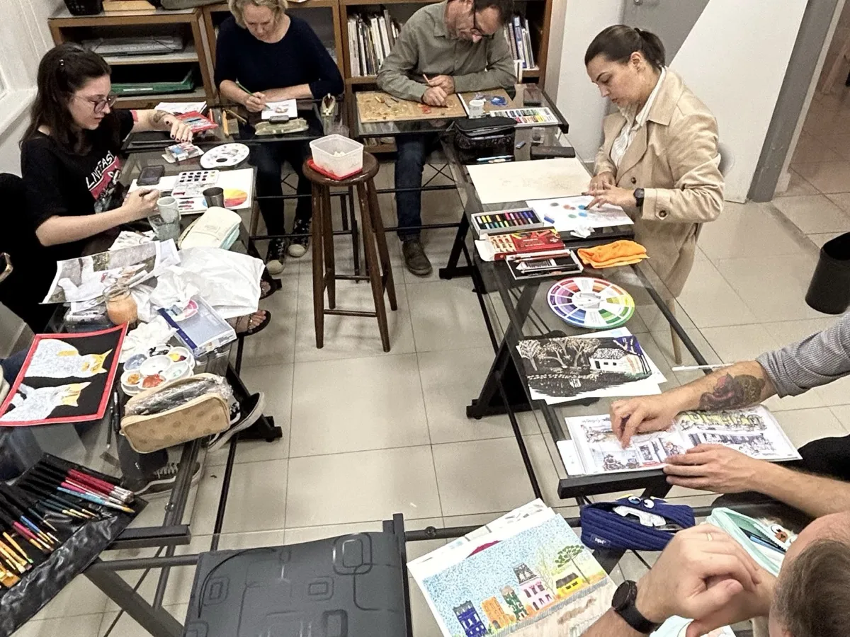 Turma desenhando e pintando nas mesas do ateliê da Desenhe